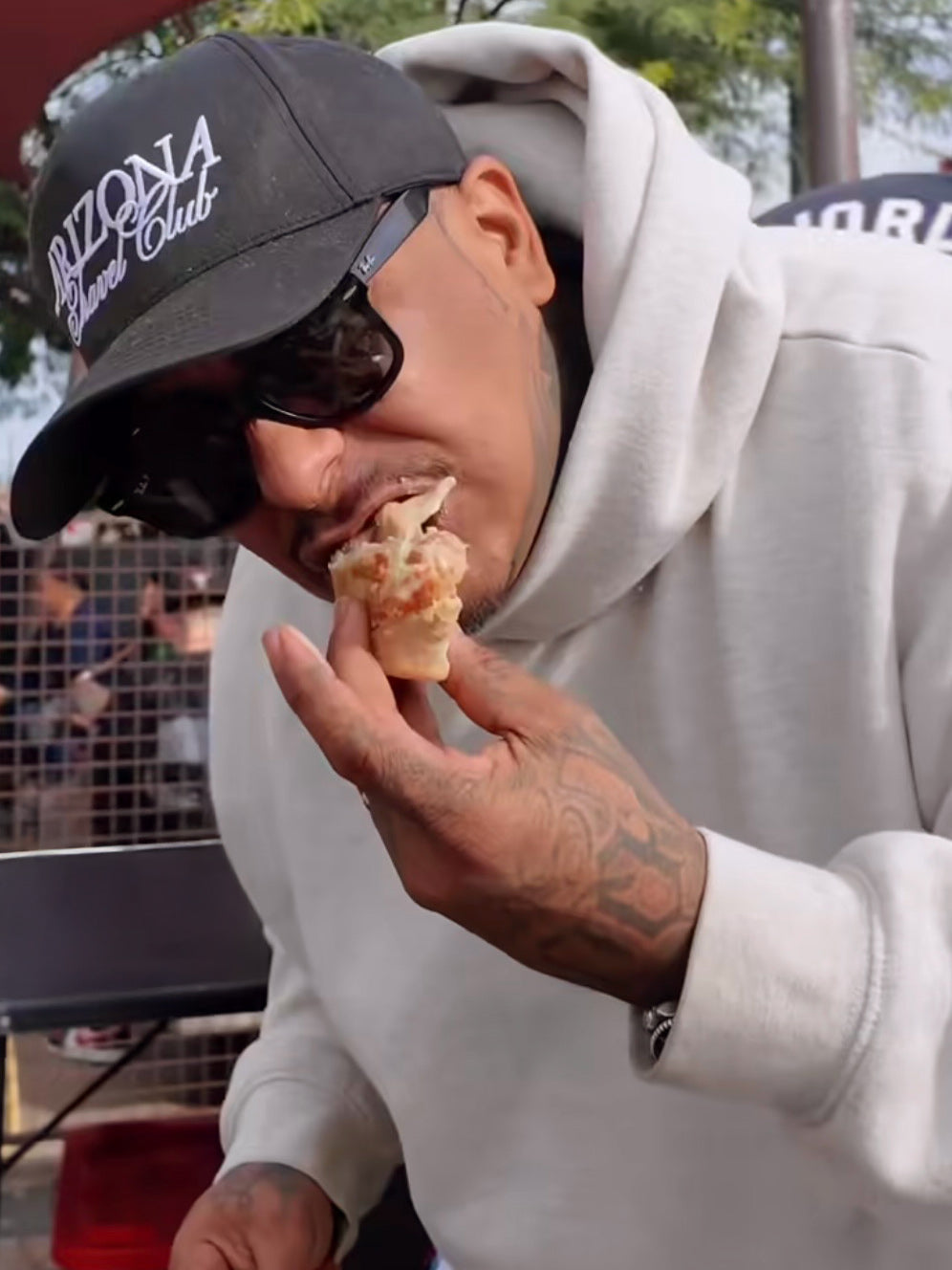 A Bad Hambres customer outside, taking a bite from a Bad Hambres burrito