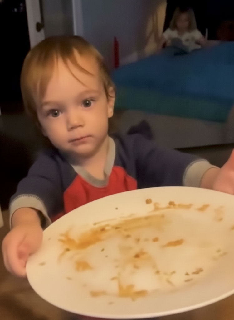 A child holding an empty plate of Bad Hambres burritos