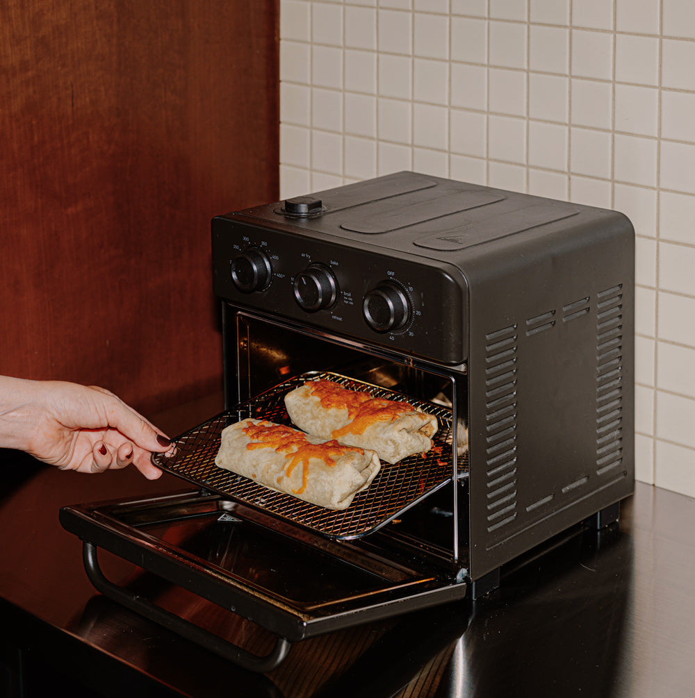 2 Bad Hambres burritos being inserted into an air fryer
